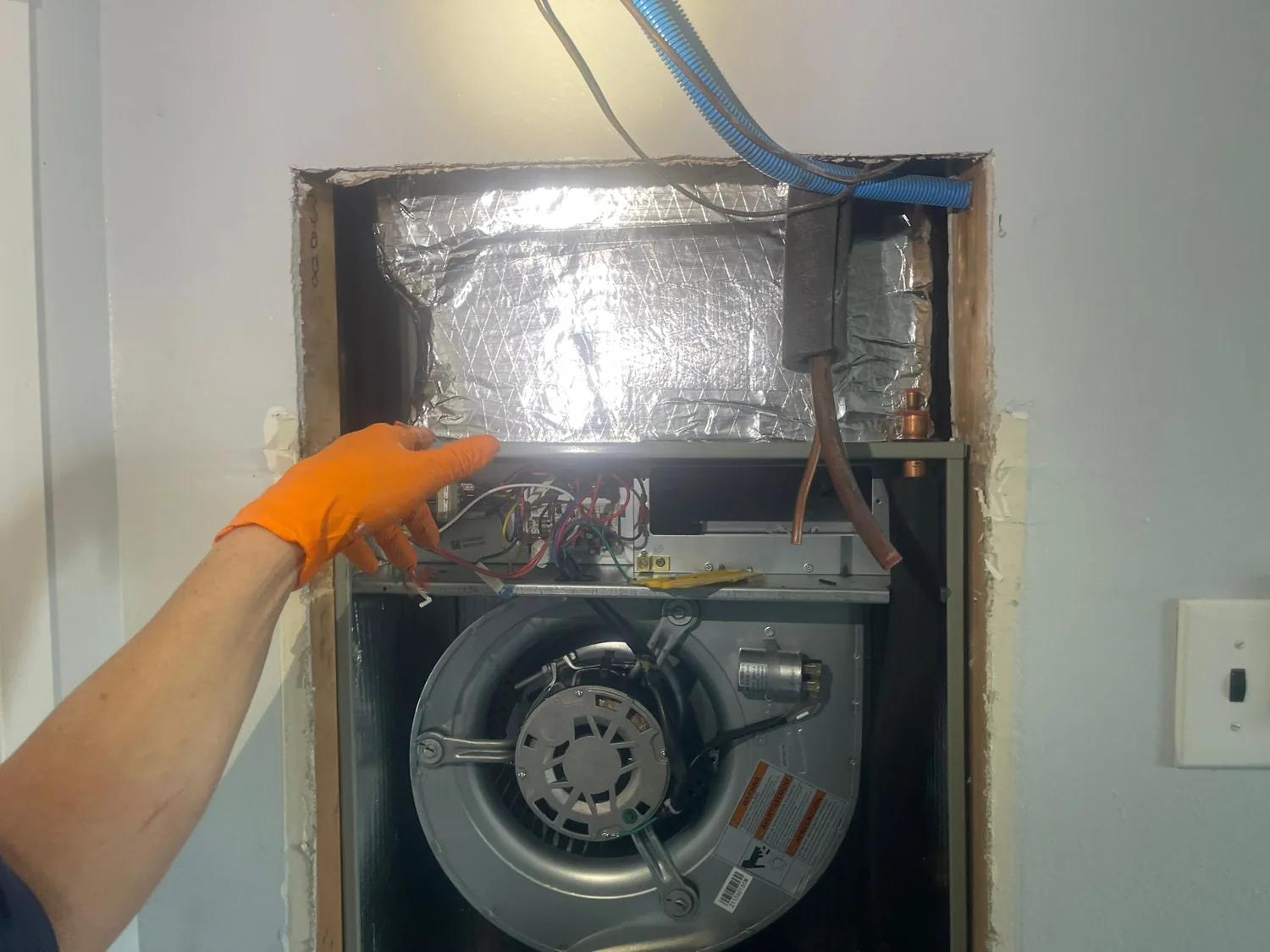 HVAC technician inspecting an air handler blower motor