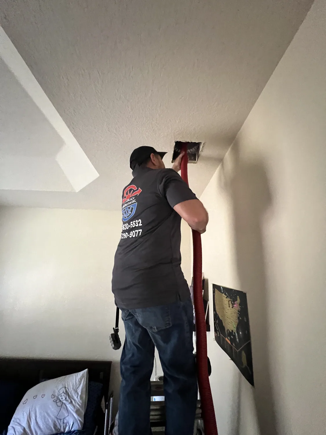 Coastline A/C technician servicing a ceiling supply vent